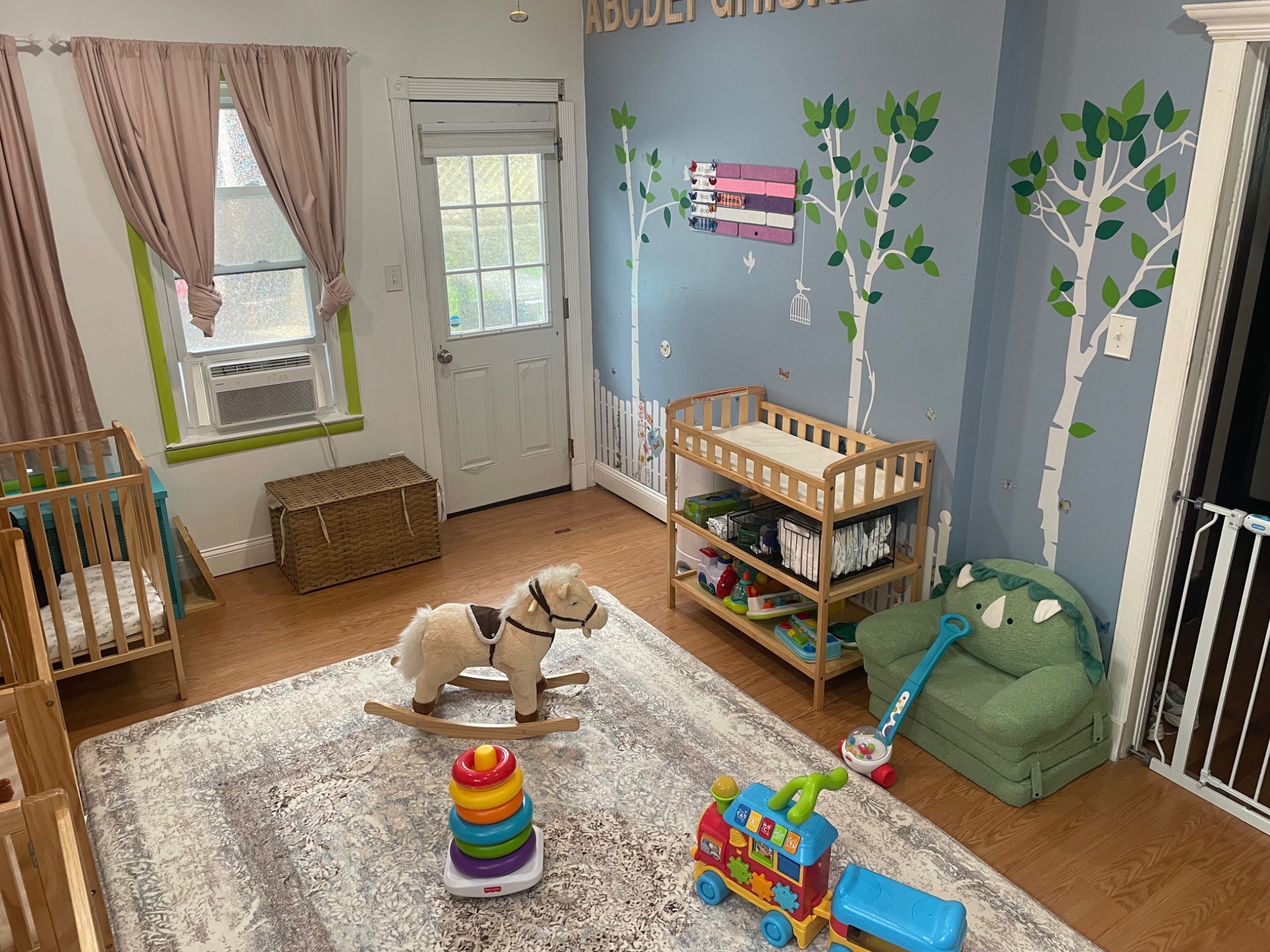 Infant room with a crib, changing area, and toys