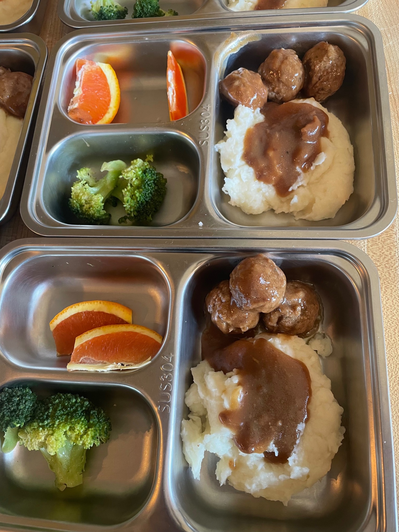 Mashed potatoes & meatballs served in daycare meal trays