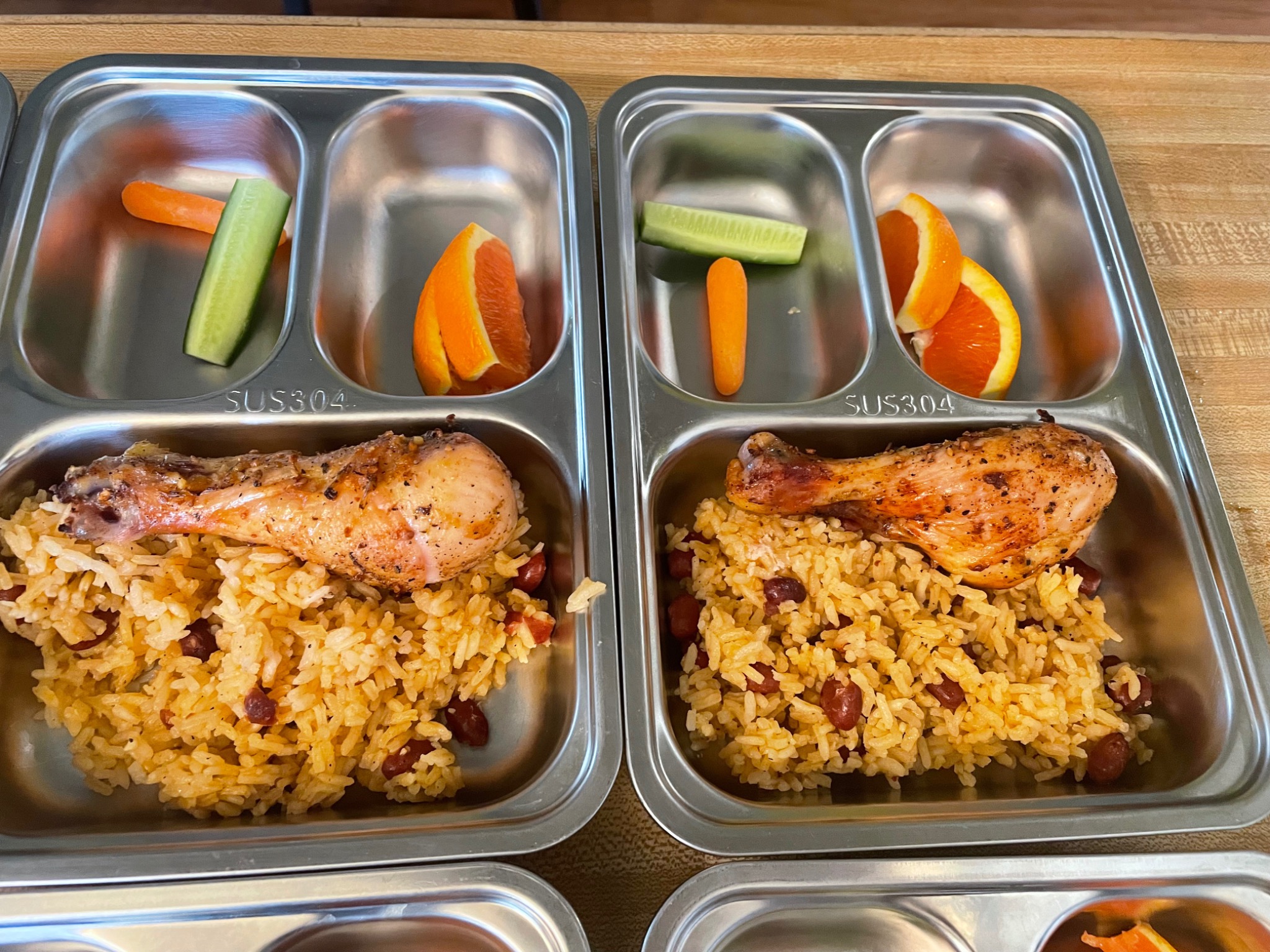 Rice & beans with roasted chicken served in daycare meal trays