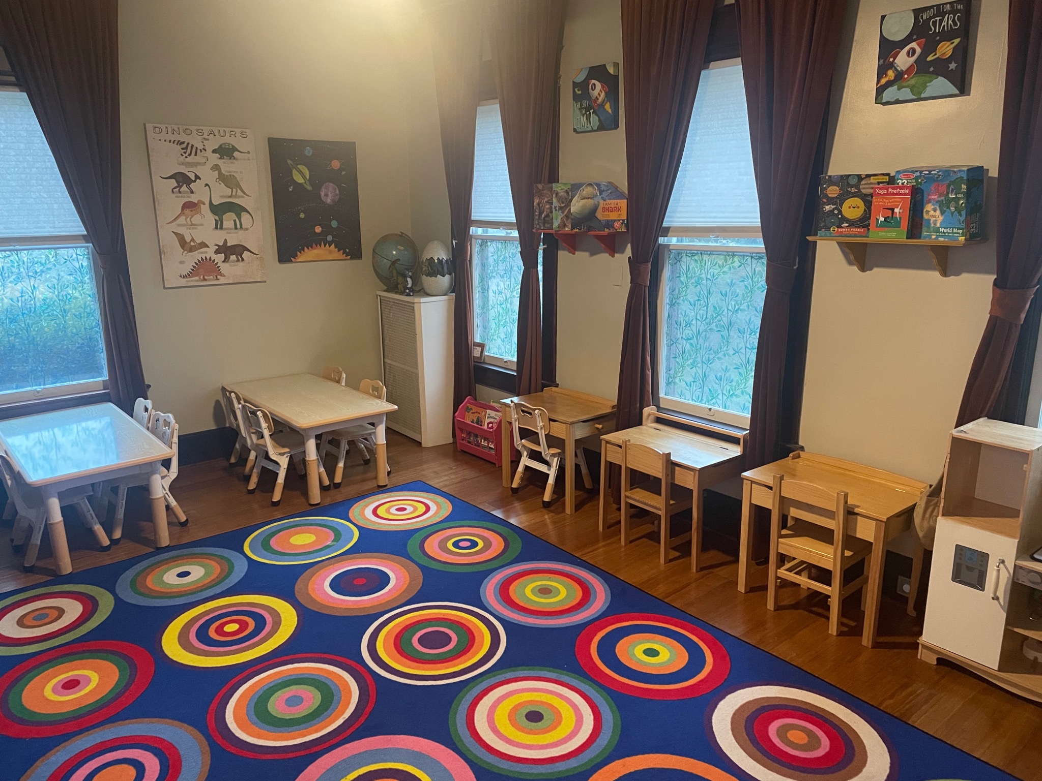 Toddler room with child-sized tables and a colorful circle rug